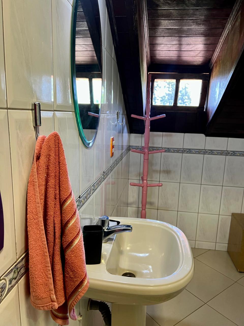 Banheiro com pia e espelho redondo