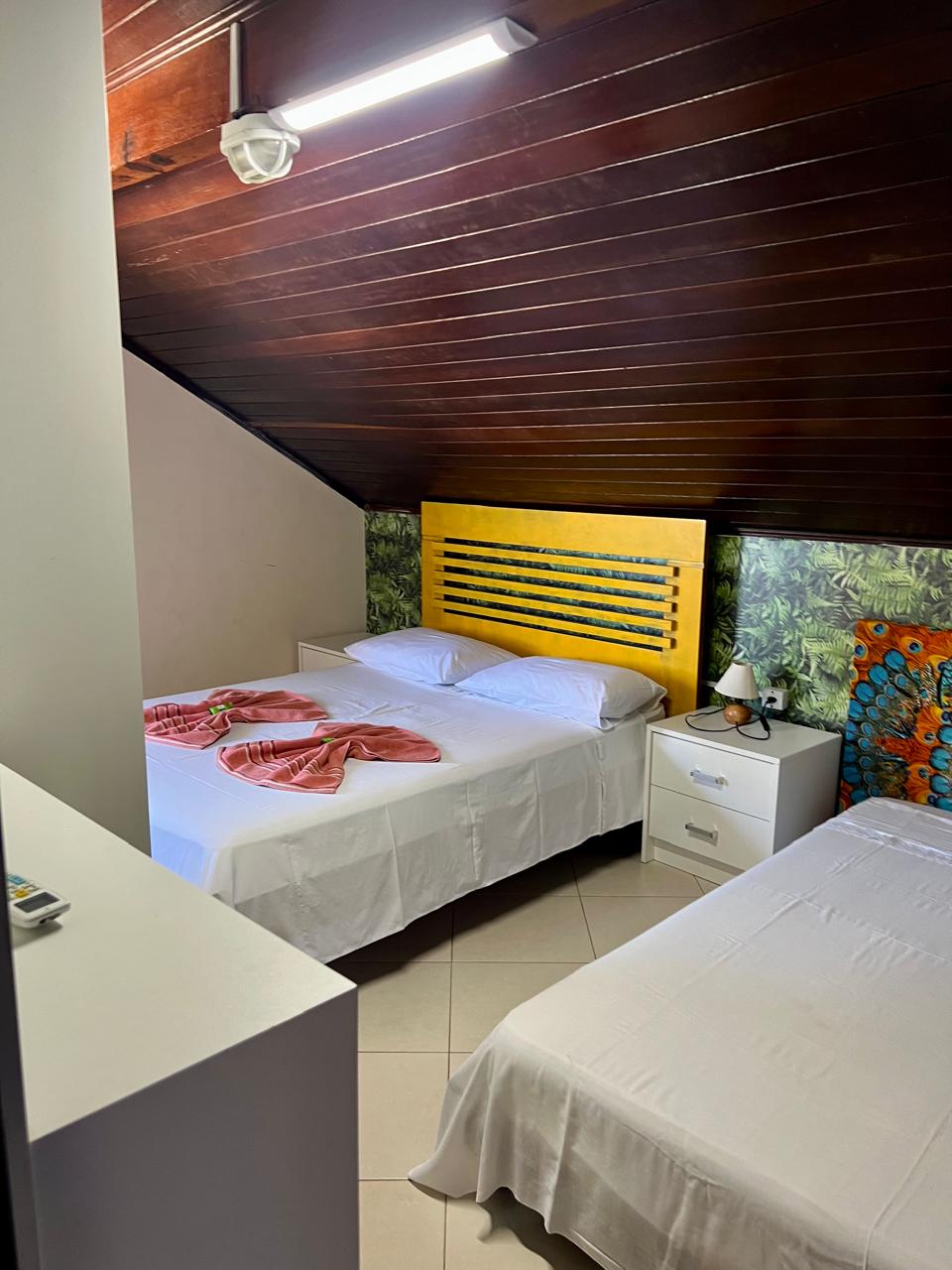 Quarto com duas camas e cabeceira amarela